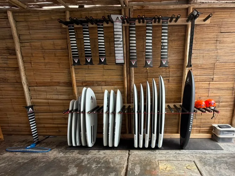 Boards and Armstrong masts arranged in the Chicama Foil Club equipment shed.