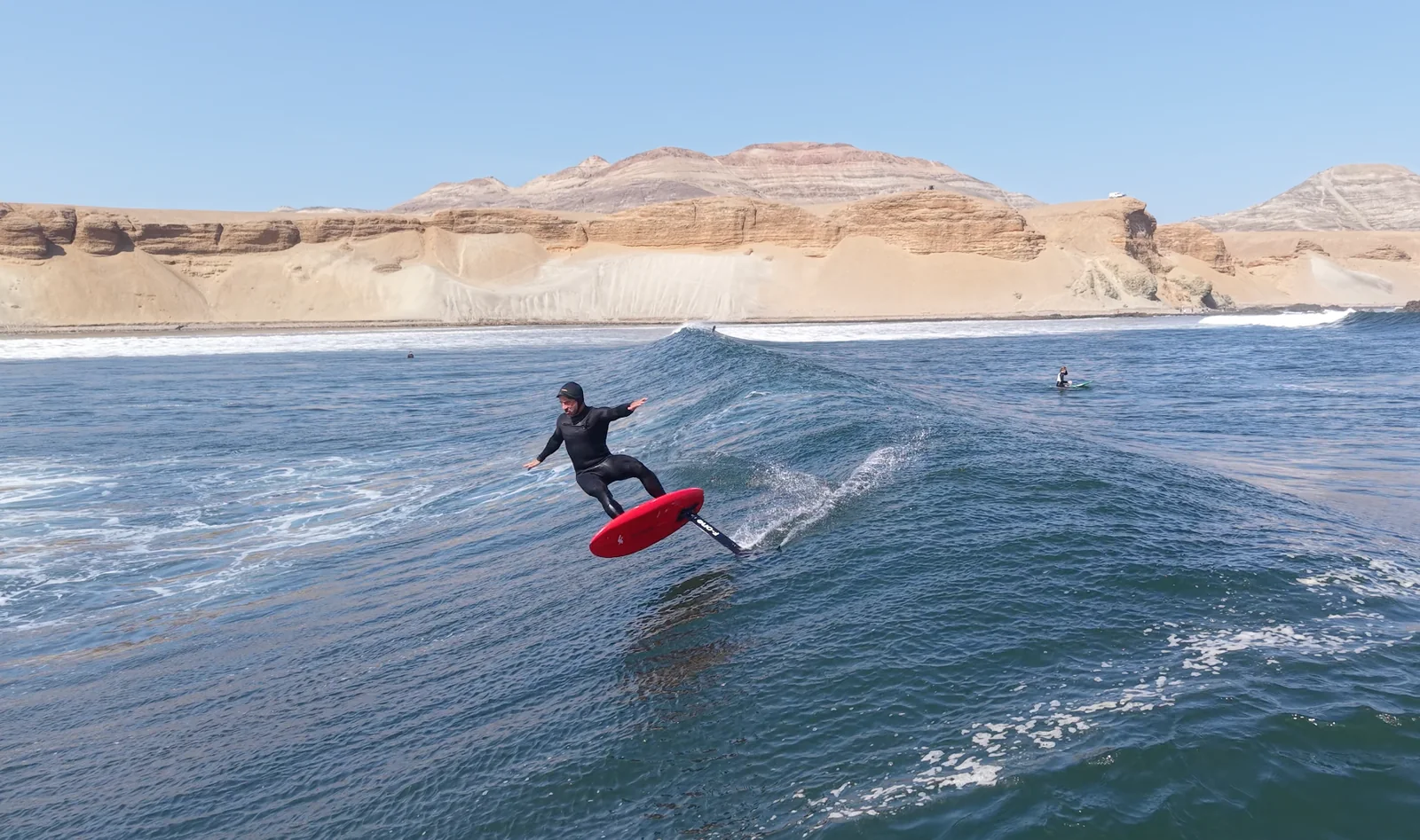 Fernando Mizo carving a foil board across a blue ocean wave.