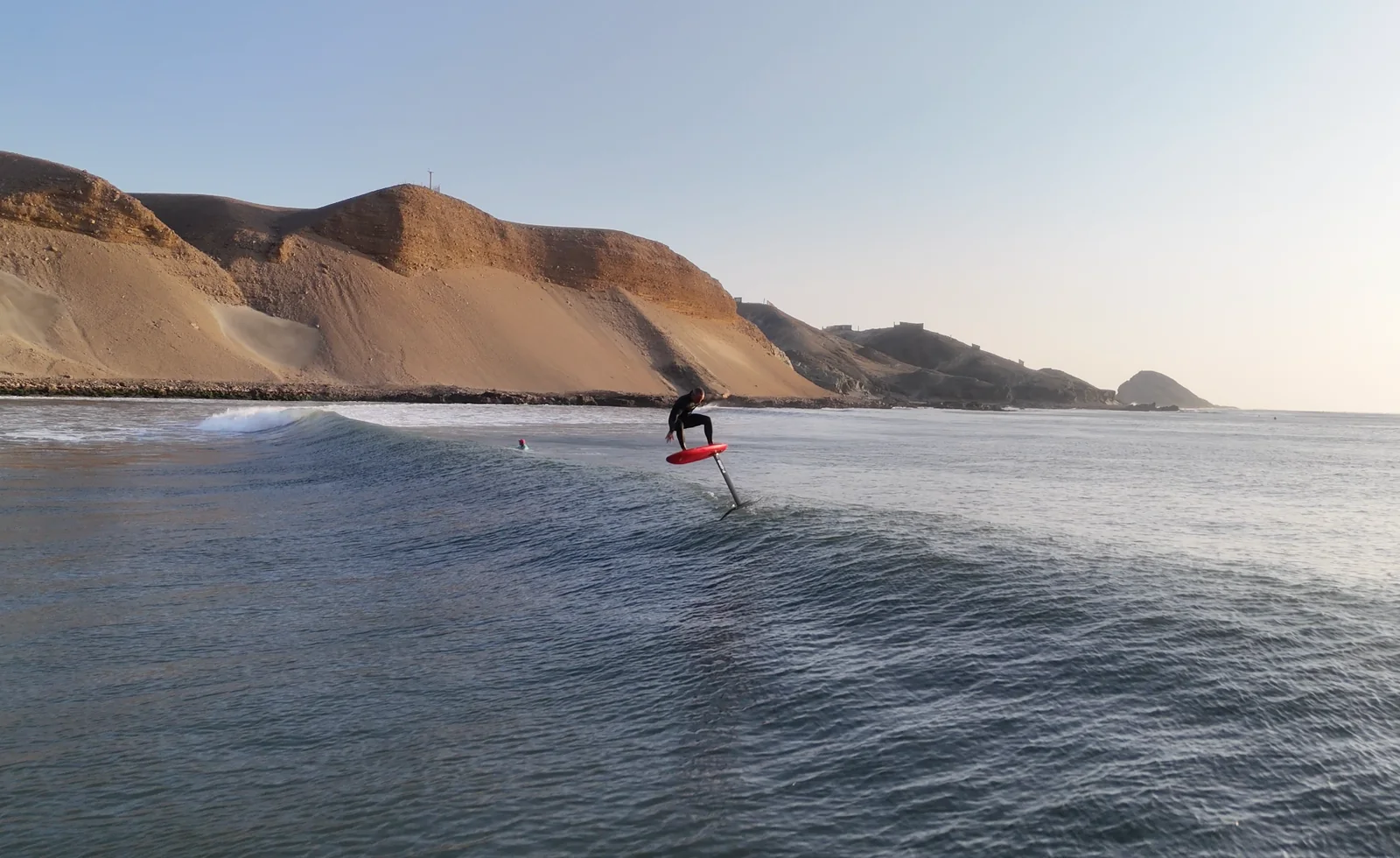 Fernando Mizo linking a long foil ride beside the Chicama coastline.