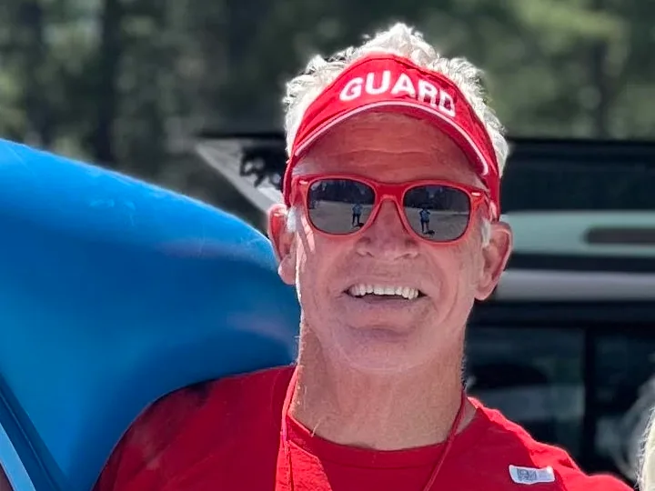 Miguel Lunceford smiling in a red lifeguard uniform.