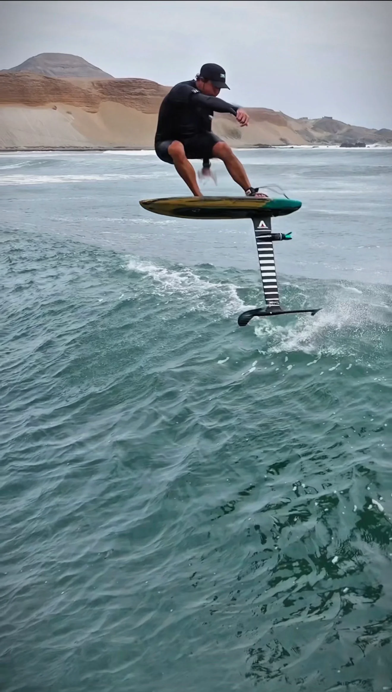 Paul Cooper lifting his foil board above the water at Chicama.