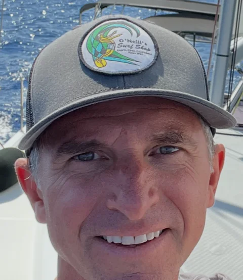 Shane Miner smiling aboard a sailboat.