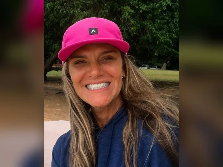 Val Rosati smiling outdoors in a bright pink Armstrong cap.